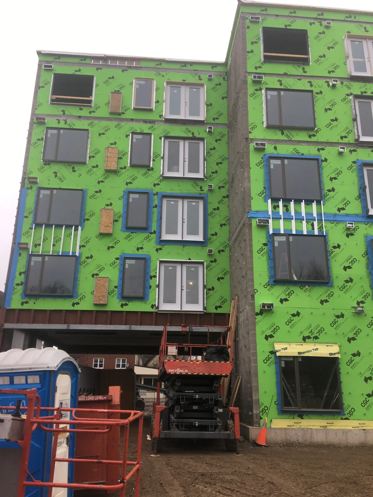 Multi-storey building wrapped in green air and vapour barrier