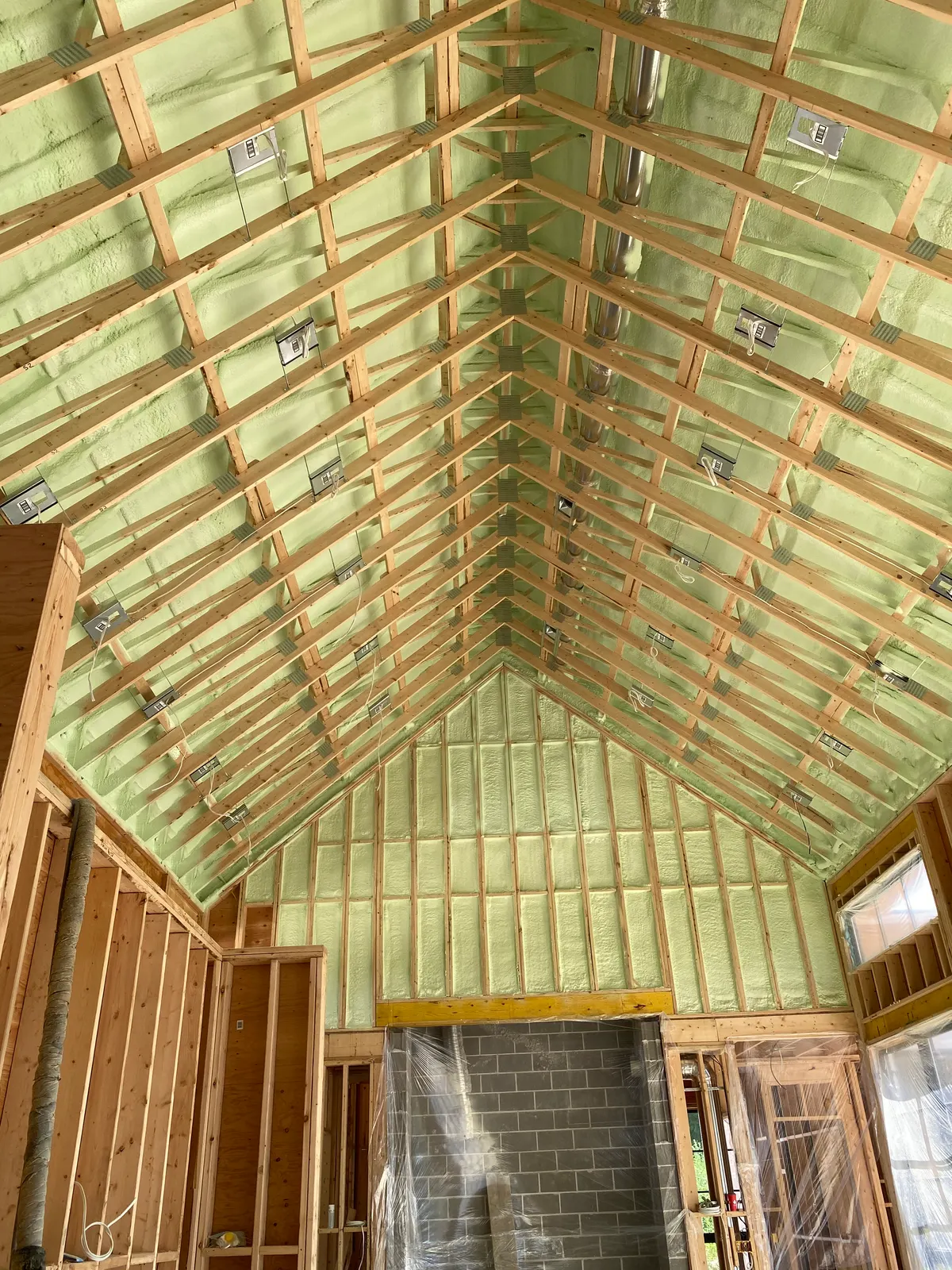 Spray foam insulation sealing a vaulted timber roof