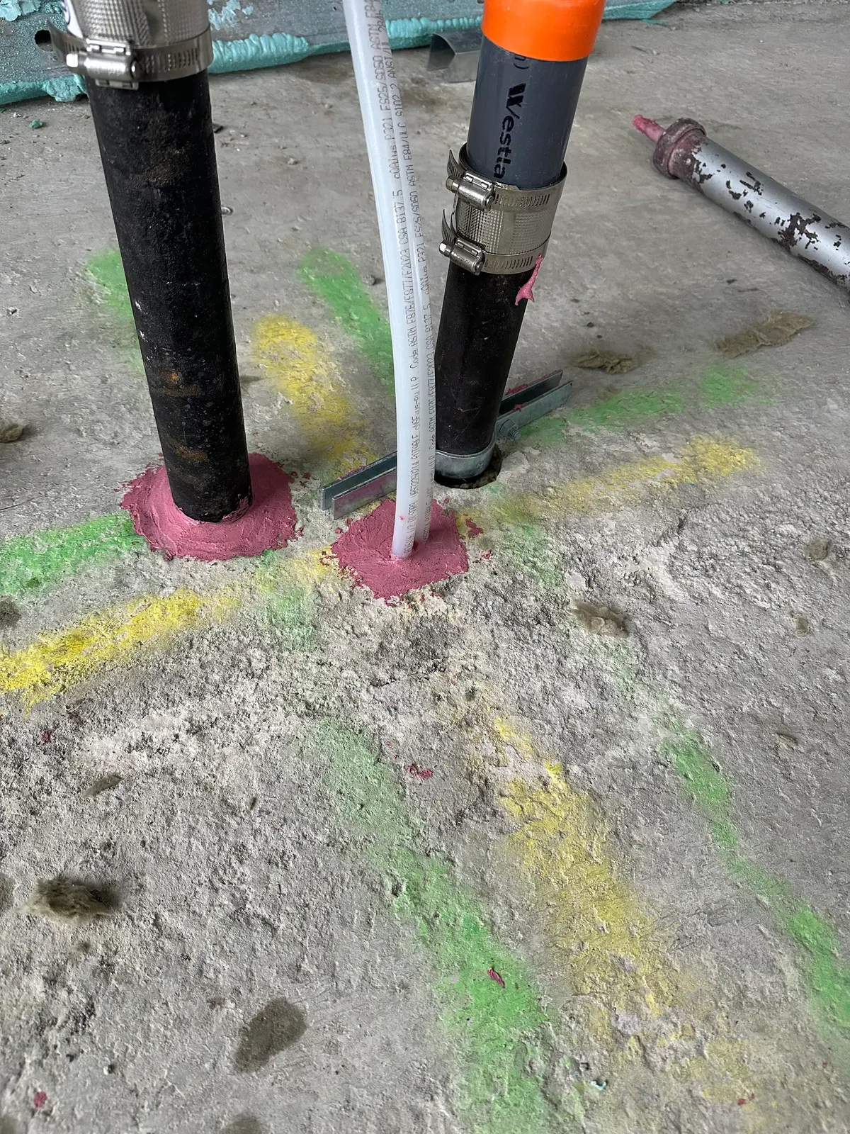 Firestopped pipe penetrations through a concrete floor